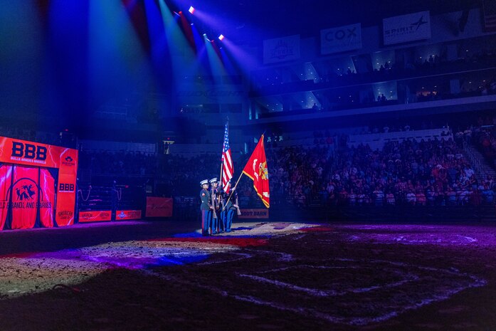 U.S. Marines with Recruiting Station Oklahoma City present the national ensign and organizational colors before a Bulls, Bands & Barrels rodeo event at INTRUST Bank Arena in Wichita, Kans., Aug. 17, 2024. The rodeo was conducted to allow the local community a chance to spectate a multitude of performances, including bull riding, barrel racing, and a musical performance. (U.S. Marine Corps photo by Cpl. Maxwell Cook)
