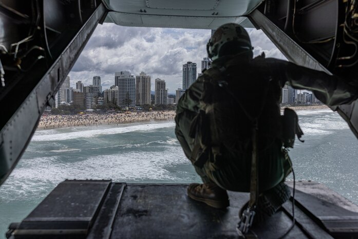 U.S. Marine Corps Cpl. Michael Rigby, an MV-22B Osprey crew chief with Marine Medium Tiltrotor Squadron 268 (Reinforced), Marine Rotational Force – Darwin 24.3, looks out the back of an MV-22B Osprey during the Pacific Airshow Gold Coast in Gold Coast, QLD, Australia, Aug. 16, 2024.