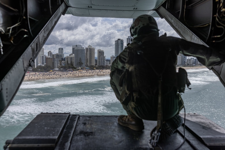 U.S. Marine Corps Cpl. Michael Rigby, an MV-22B Osprey crew chief with Marine Medium Tiltrotor Squadron 268 (Reinforced), Marine Rotational Force – Darwin 24.3, looks out the back of an MV-22B Osprey during the Pacific Airshow Gold Coast in Gold Coast, QLD, Australia, Aug. 16, 2024.