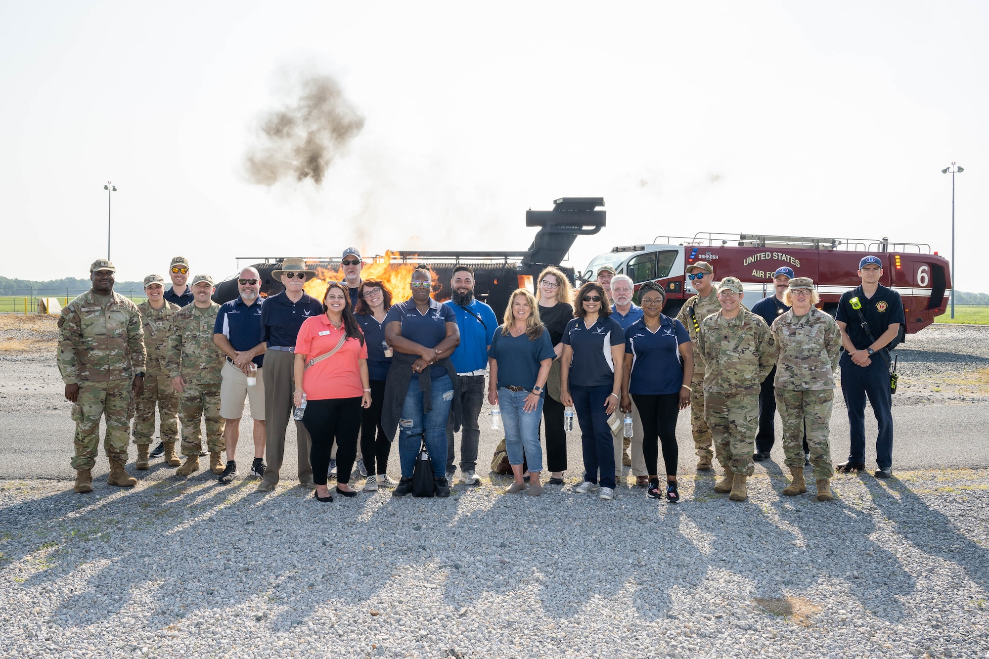 A group of honorary commanders pose with members of the 436th and 512th Mission Support Groups in front of an aircraft-fire trainer and a fire truck at Dover Air Force Base, Delaware, Aug. 15, 2024. The HCCs toured various elements of the 436th MSG to familiarize them with the group's mission and capabilities. (U.S. Air Force photo by Mauricio Campino)