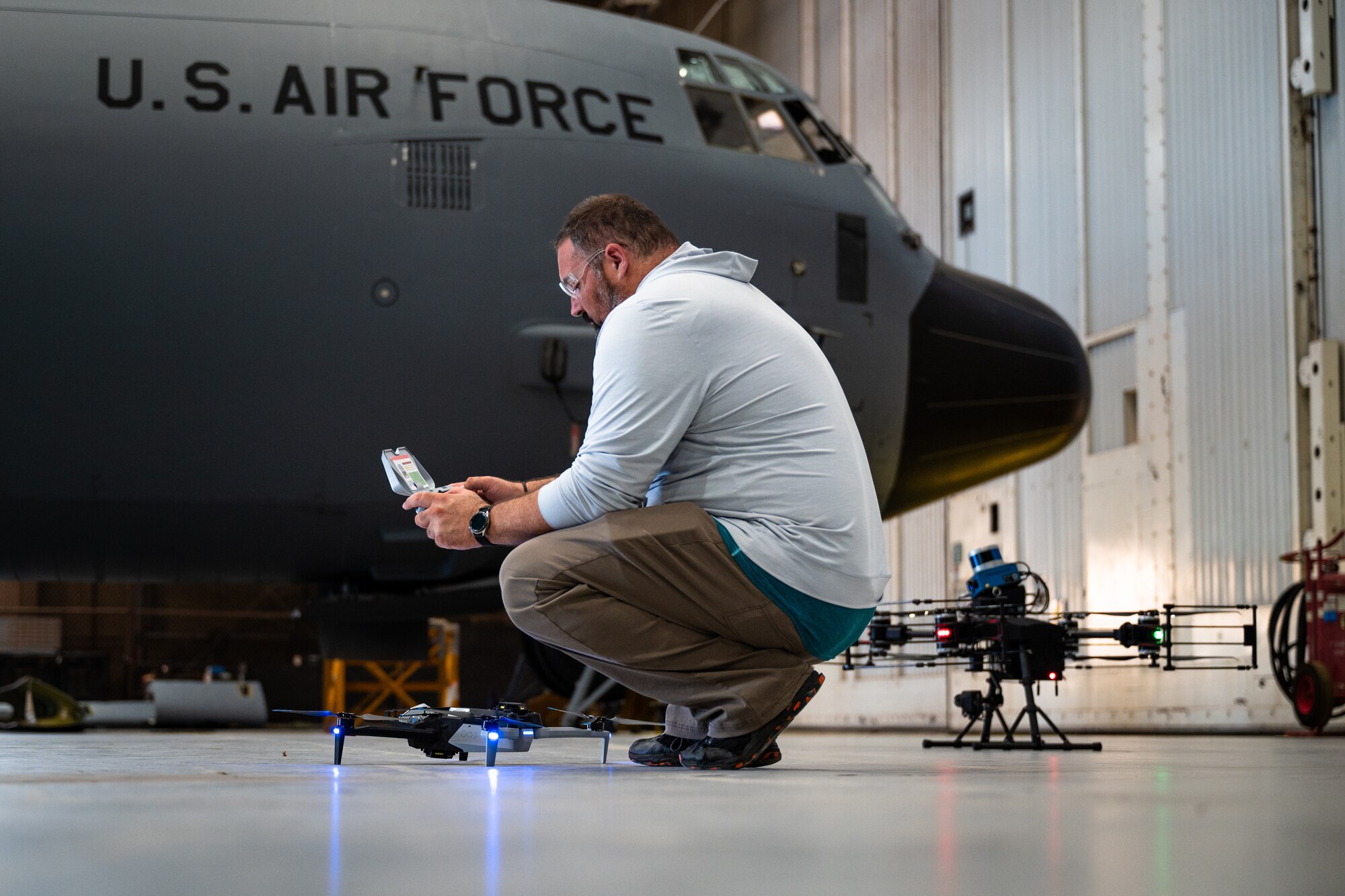 Jasen Hansen, Boeing scientific photographer and drone pilot, sets up a Boeing-operated Skydio X-10D at Dyess Air Force Base, Texas, Aug. 14, 2024. The demonstration showed how Dyess can work with Boeing and small businesses to innovate processes for Airmen, such as detecting aircraft anomalies using drone imagery. While small business partners operated larger systems with flight patterns using installed aircraft schematics, Boeing operated a smaller drone that can fit into a backpack to show how Airmen can use the Automated Damage Detection Software in more flexible situations. Dyess and Boeing share a mission to innovate and increase aircraft availability by targeting maintenance problems. (U.S. Air Force photo by Airman 1st Class Jade M. Caldwell)