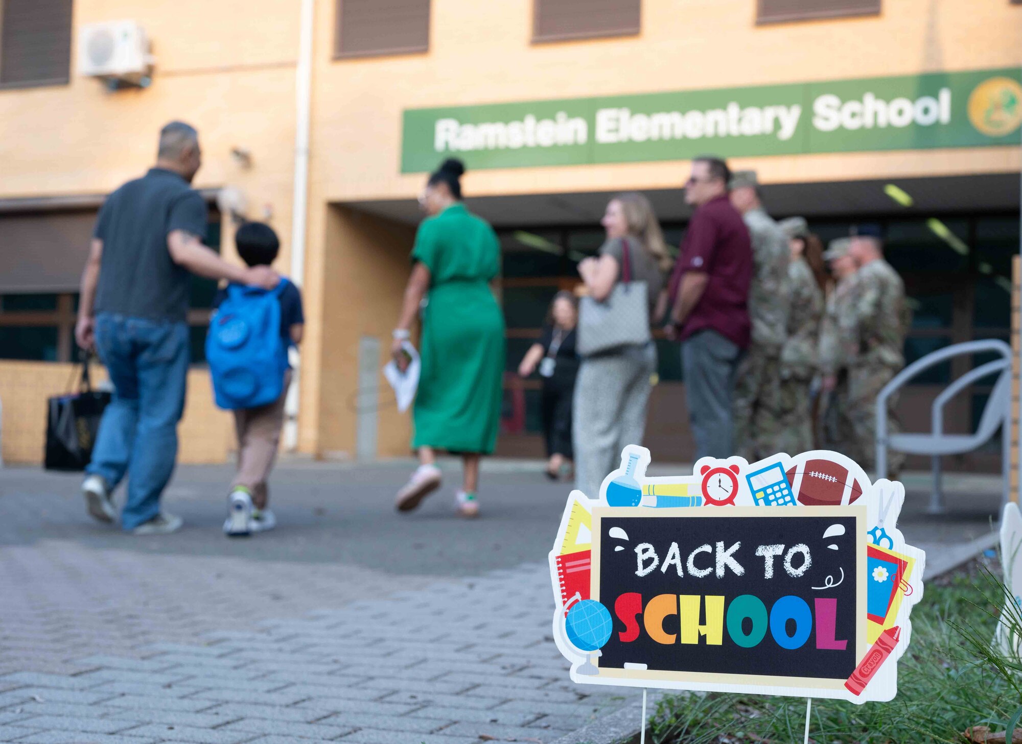 A student is greeted by U.S. service members on the first day of school at Ramstein Elementary School, Germany, Aug. 19, 2024.