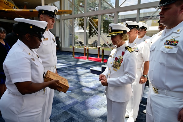 Senior Chief Nevilin Davis assigned to Navy Medicine Operational Training Command presents the outgoing commander, Capt. Kimberly P. Toone with her chief's vessel as she is made an honorary member of the NMOTC Chief's Mess during a change of command ceremony, Aug. 14. NMOTC as a command oversees six detachments and 12 training centers, with facilities in over 60 locations across the United States. These facilities support training programs in aviation, surface and undersea warfare, expeditionary forces, and special operations, providing medical training for the Navy, other U.S. armed forces, and allied nations. (U.S. Navy photo by Mass Communication Specialist 1st Class Russell Lindsey SW/AW)