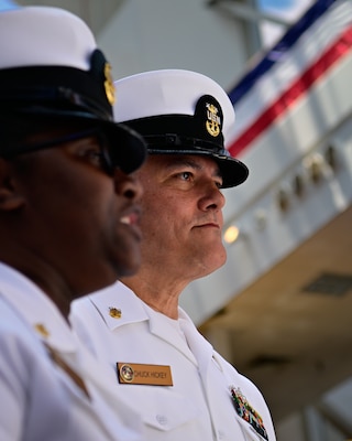 Command Master Chief Charles Hickey assigned to Navy Medicine Operational Training Command looks on as Senior Chief Nevilin Davis presents the outgoing commander, Capt. Kimberly P. Toone with her chief's vessel as she is made an honorary member of the NMOTC Chief's Mess during a change of command ceremony, Aug. 14. NMOTC as a command oversees six detachments and 12 training centers, with facilities in over 60 locations across the United States. These facilities support training programs in aviation, surface and undersea warfare, expeditionary forces, and special operations, providing medical training for the Navy, other U.S. armed forces, and allied nations. (U.S. Navy photo by Mass Communication Specialist 1st Class Russell Lindsey SW/AW)