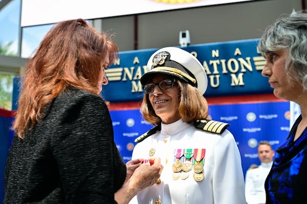 Capt. Nichole Olson is pinned with the Command Ashore pin by her sister during a change of command ceremony for the Navy Medicine Operational Training Command (NMOTC) held aboard Naval Air Station Pensacola, Aug. 14. The Command oversees six detachments and 12 training centers, with facilities in over 60 locations across the United States. These facilities support training programs in aviation, surface and undersea warfare, expeditionary forces, and special operations, providing medical training for the Navy, other U.S. armed forces, and allied nations. (U.S. Navy photo by Mass Communication Specialist 1st Class Russell Lindsey SW/AW)