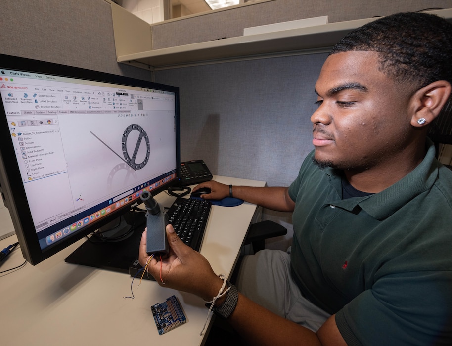 N. Charleston, SC (July 30, 2024) Naval Information Warfare Center (NIWC) Atlantic student intern Darrian Wilson designs a part in Solidworks for 3D printing. NIWC hosted 94 talented student interns this summer in support of continued learning in STEM and furthering innovation in the information warfare battlespace. Interns got hands-on experience in multiple areas installation and integration of software, cyber operations development for mobile devices, server configuration, vulnerability testing and more. The NIWC Atlantic Student Intern program is designed to provide an internship for students currently enrolled in school at a collegiate level. Students follow a developmental plan that provides a roadmap for potential future employment at NIWC Atlantic.