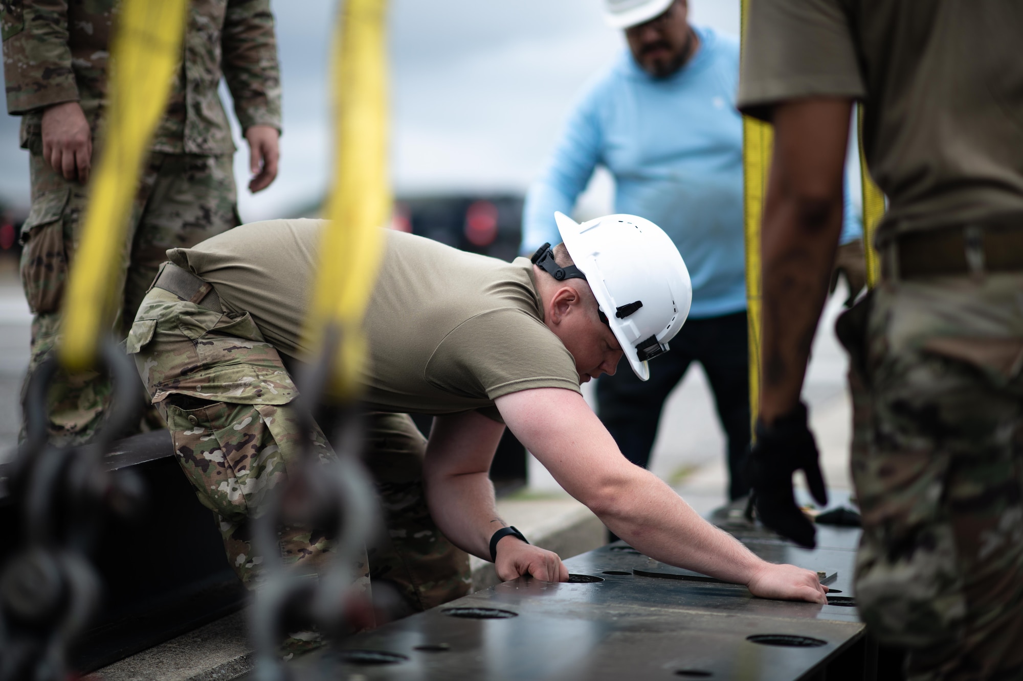 Senior Airman Michael McCluskey adjusts a fairlead beam into place.