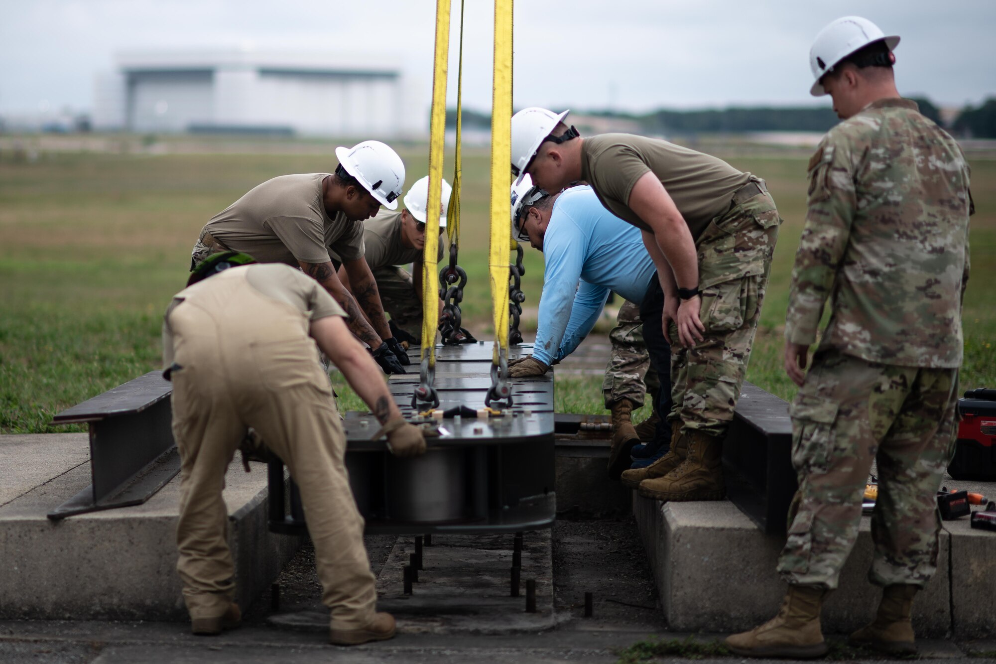 Personnel with the 316th Civil Engineer Squadron maneuver a fairlead beam into place during the overhaul of the BAK-12 aircraft arresting system.