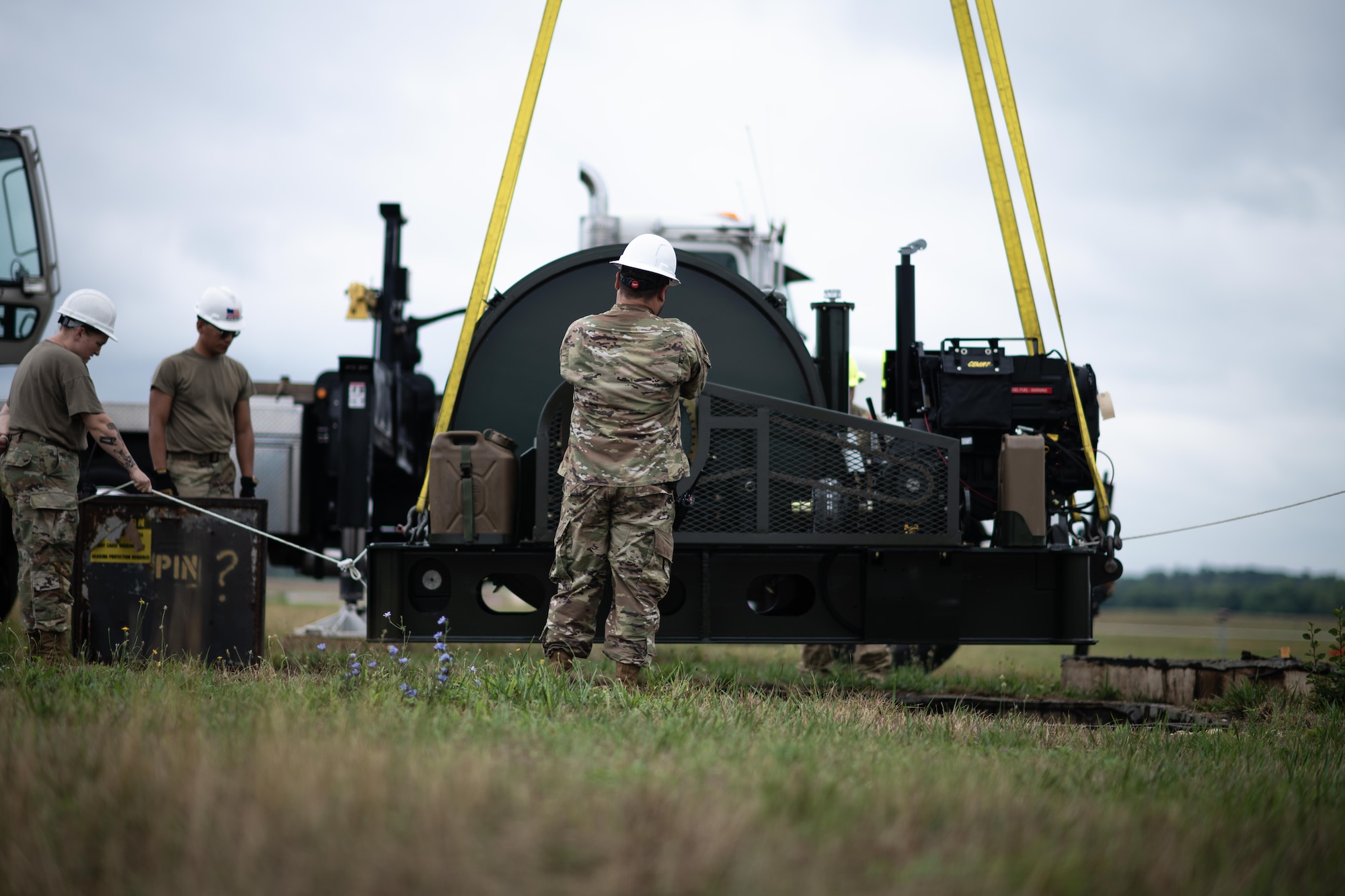The BAK-12 aircraft arresting system is maneuvered into its housing by Airmen of the 316th Civil Engineer Squadron.