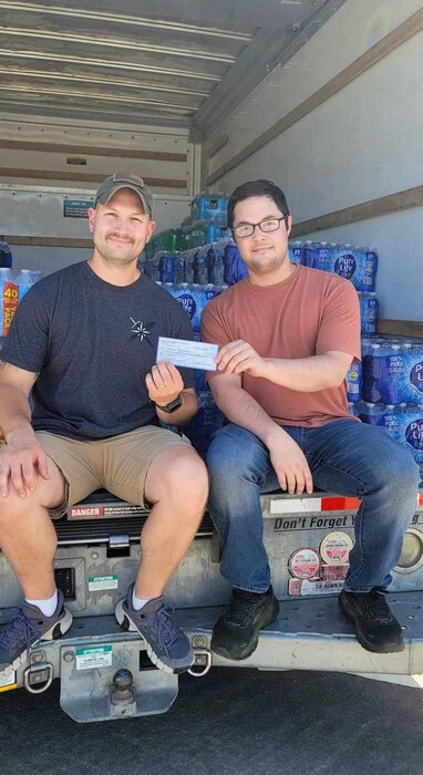U.S. Air Force Capt. Joshua Bowman, left, and Staff Sgt. Dalton Kennard, right, 315th Training Squadron instructors, pose for a photo in front of relief aid at Goodfellow Air Force Base, Texas, July 15, 2024. (Courtesy Photo)