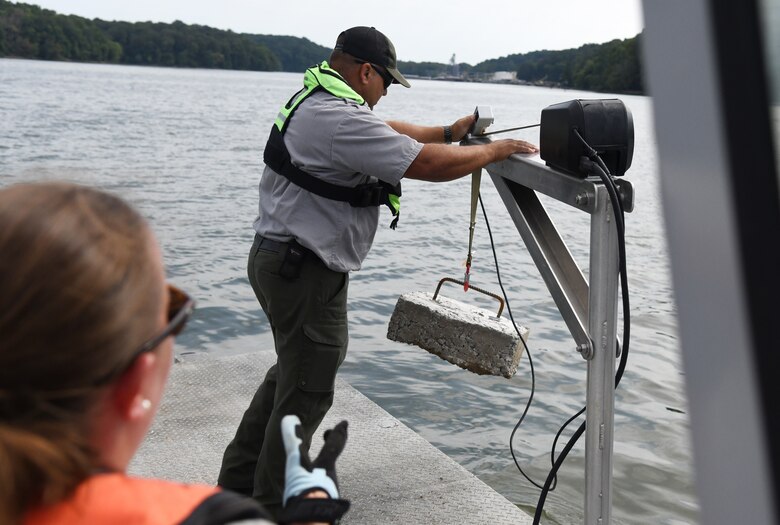U.S. Army Corps of Engineers Ranger Danielle Packer (left) looks on as Ranger David Landis positions a buoy anchor near the edge of the boat at Lake Barkley in Kuttawa, Kentucky, Aug. 14, 2024.
