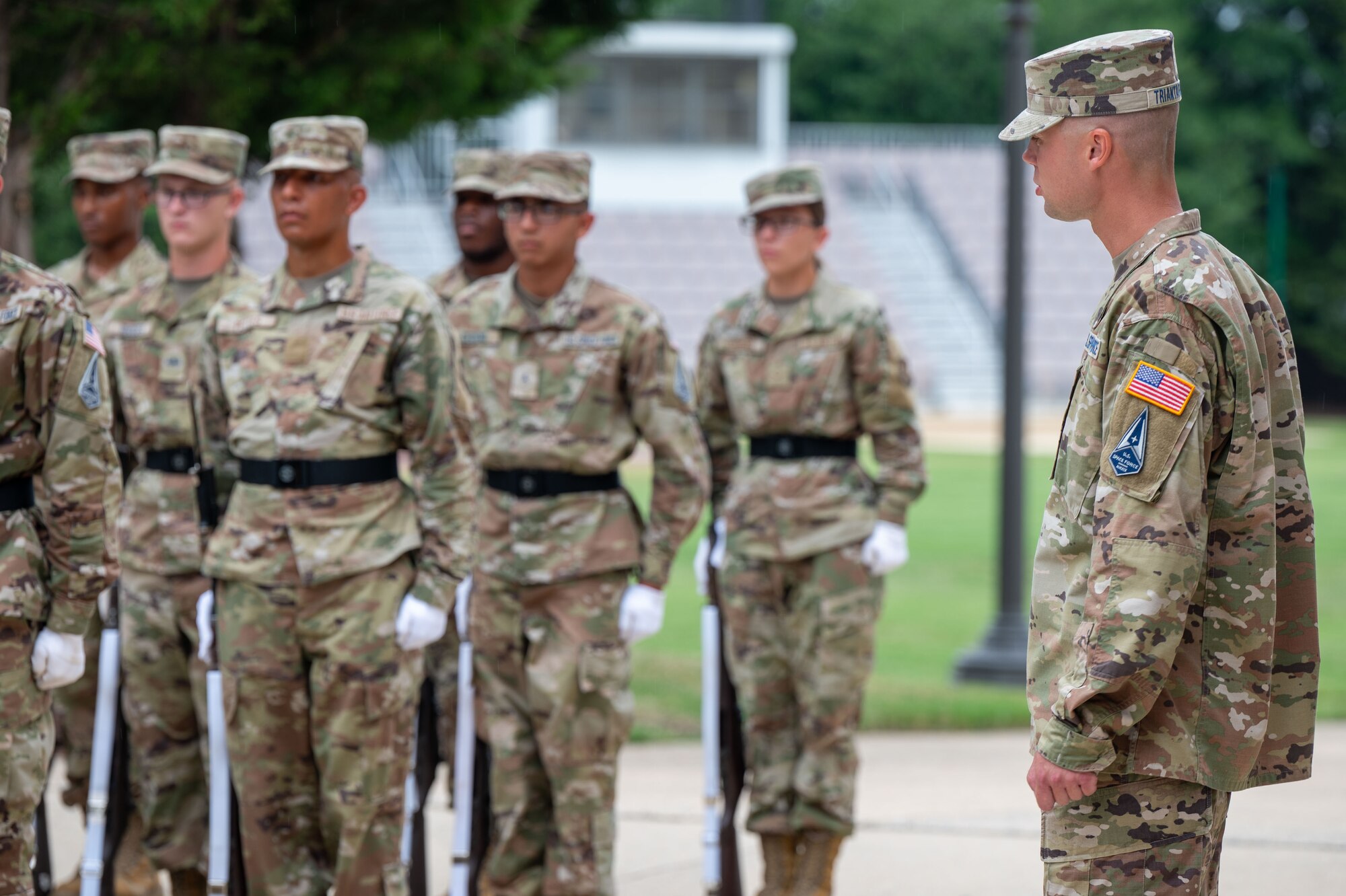 a technical training instructor with the United States Air Force Honor Guard, looks on as Honor Guard trainees of Class 24D work on their drill movements