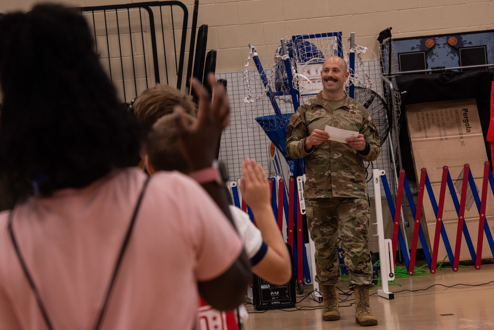 Chief Master Sgt. Austin Sutton, 4th Operations Support Squadron senior enlisted leader, administers a ‘kids’ oath of enlistment’ during an “OPERATION Bug Out” kids’ mock deployment.