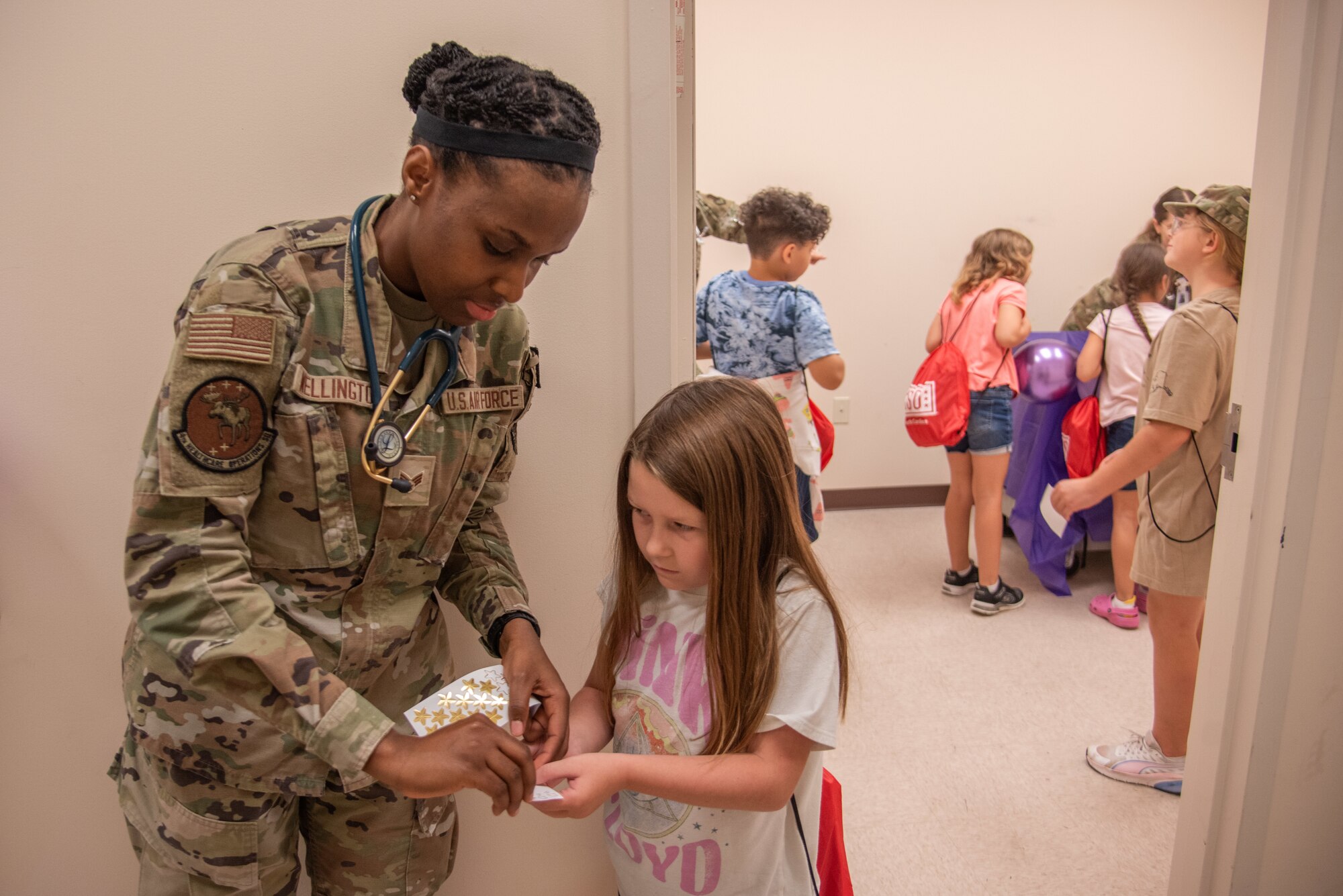 SrA Taysha Wellington, 4th HCOS aerospace medical service technician, simulates medically clearing a military child dependent for an “OPERATION Bug Out” kids’ deployment.
