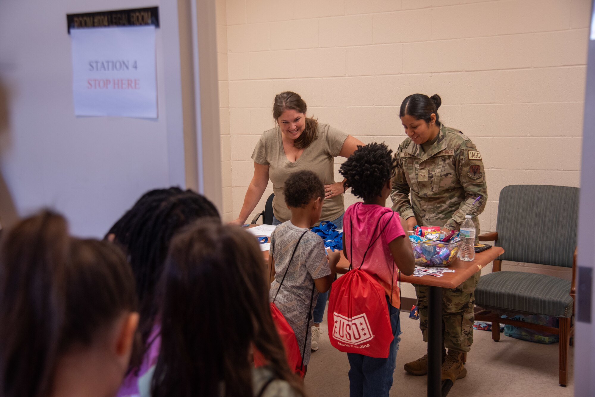 Ashley Gadd, left, 4th Fighter Wing judge advocate office discharge clerk, and Senior Airman Maricel Castro, right, 4th FW JA office military justice paralegal, help military child dependents fill out a mock power of attorney during an “OPERATION Bug Out” kids’ deployment.