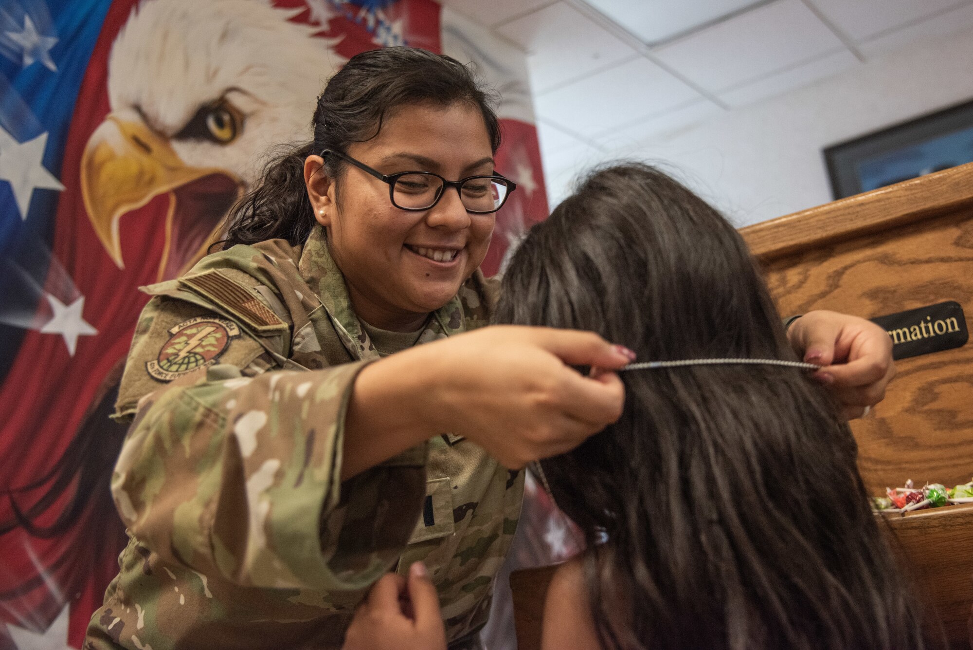 1st Lt. Ana Rodriguez, 4th FSS MPF commander, presents a military child dependent with mock dog tags during an “OPERATION Bug Out” kids’ deployment.