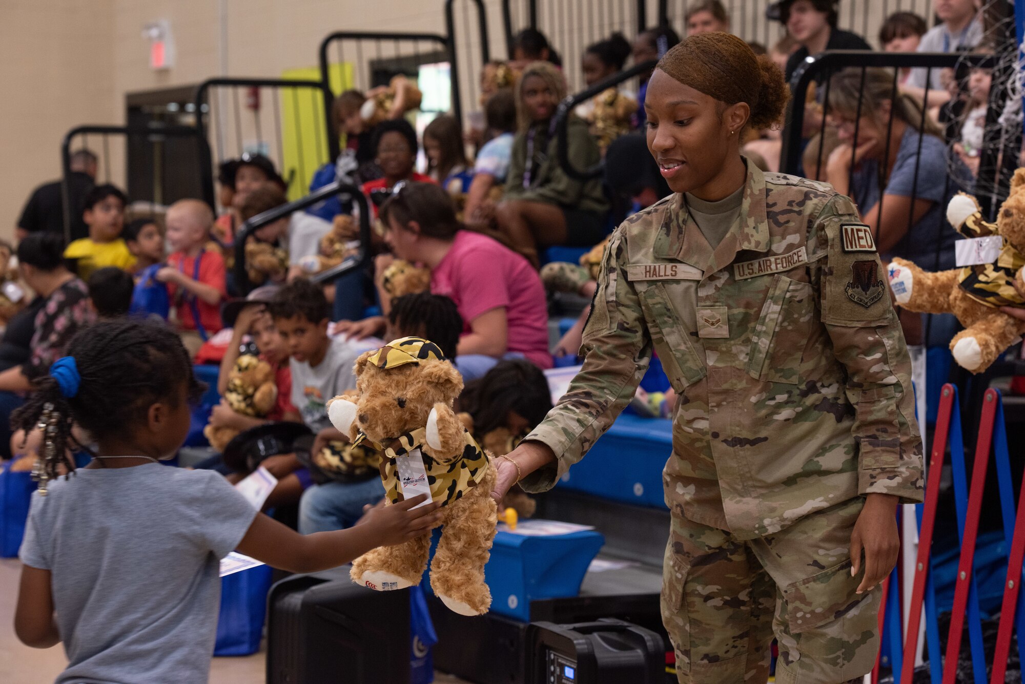 SrA Zhaferria Halls, 4th OMNRS, hands out stuffed animals to children of service members.