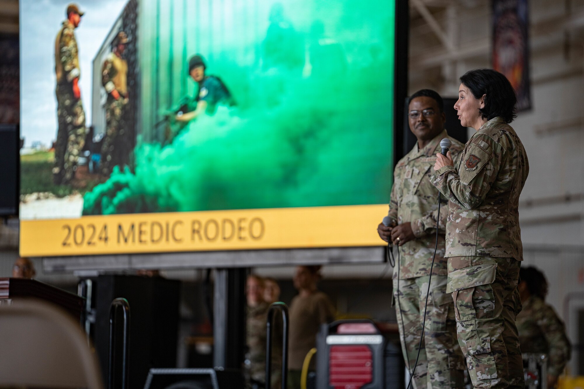 U.S. Air Force Chief Master Sgt. Jerry Dunn, command chief of Air Force Medical Command, and Maj. Gen. Jeannine M. Ryder, commander of the Air Force Medical Agency and director of the Defense Health Network Continental, give a speech during Medic Rodeo 2024 opening ceremony at Cannon Air Force Base, New Mexico, Aug. 12, 2024. Ryder observed demonstrations during the 15th annual Medic Rodeo as part of her visit to Cannon AFB. The objective of Medic Rodeo is to create a prepared joint medical force through realistic and demanding training aimed at emerging readiness needs. (U.S. Air Force photo by Senior Airman Mateo Parra)