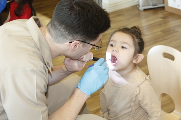 A U.S. Navy dentist checks the teeth of a youth at the Child Development Center on Naval Support Activity Bethesda during 2020's Children Dental Health Month, annually observed during February. Navy dentists are stationed at military treatment facilities, dental education institutions, clinics, hospitals, research units, on ships, and with Marine Forces located within the United States and various overseas locations.