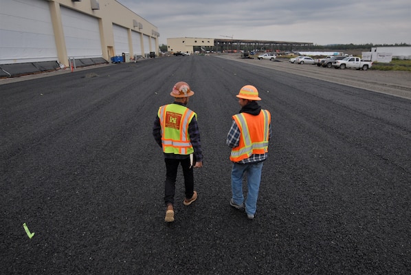 USACE construction personnel walk near a recently completed hangar complex for newly stationed F-35s at Eielson Air Force Base near North Pole, Alaska. The Department of Defense invested about $600 million on a beddown program at the installation located near North Pole, Alaska. Also known as the “joint strike fighter,” two new squadrons of 54 aircraft now have the proper facilities to support their missions thanks to the design and construction work of the U.S. Army Corps of Engineers – Alaska District.