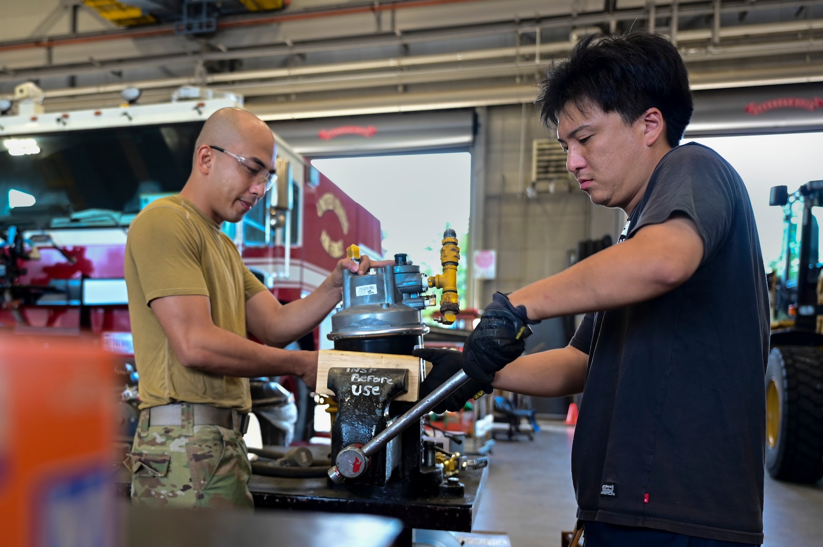 U.S. Air Force Senior Airman Micheal Angel Lou Ocaya, left, and Ryohei Hamada, 35th Logistic Readiness Squadron (LRS) firetruck and refueler maintainers, perform equipment repairs at Misawa Air Base, Japan. Aug. 19, 2024.