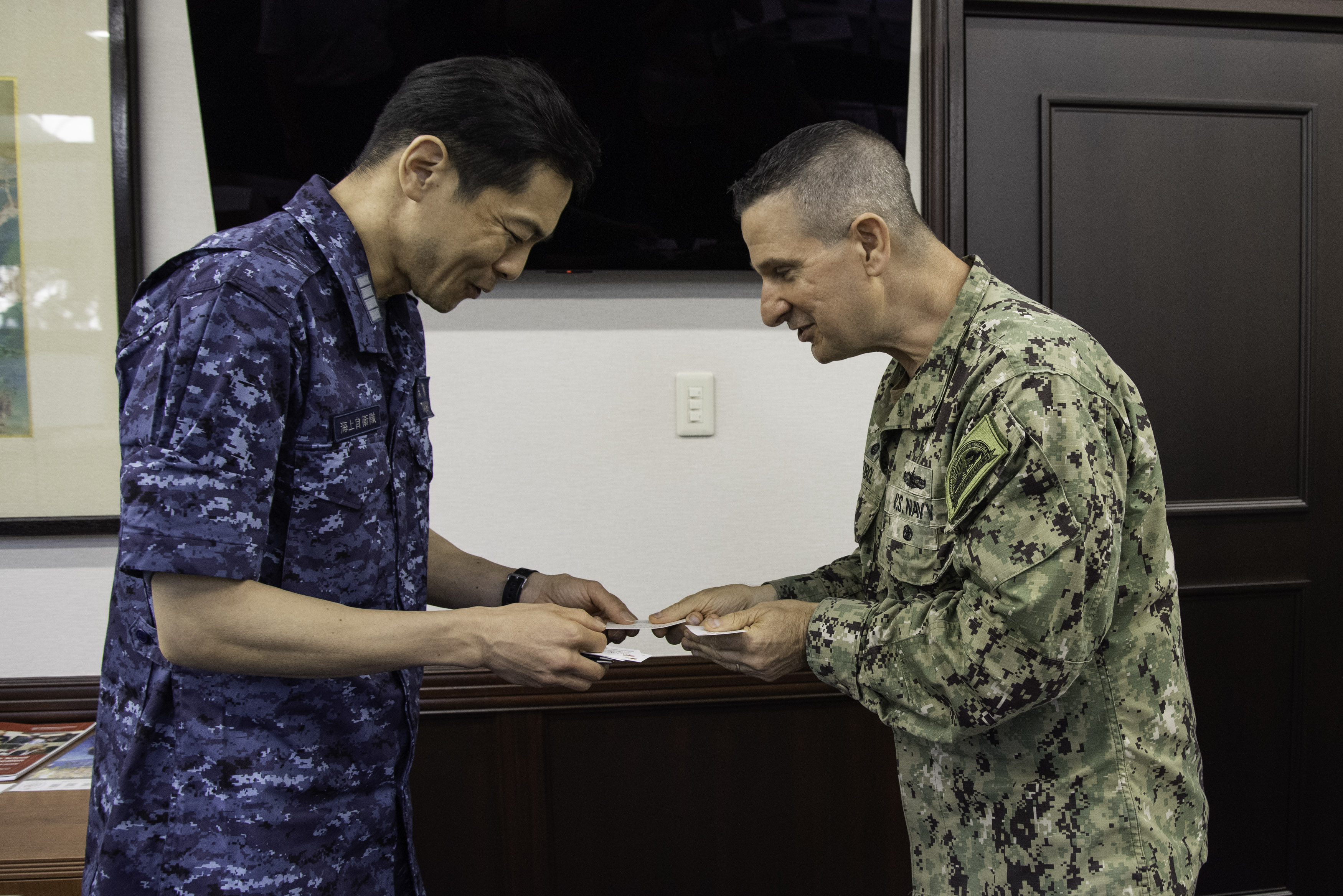 Capt. Les Sobol, Commander, Fleet Activities Yokosuka, welcomes Japan Maritime Self-Defense Force (JMSDF) Liaison Officer, Capt. Masaaki Takashima of JMSDF Yokosuka District in the installation commanding officer’s office at CFAY headquarters August 19, 2024.