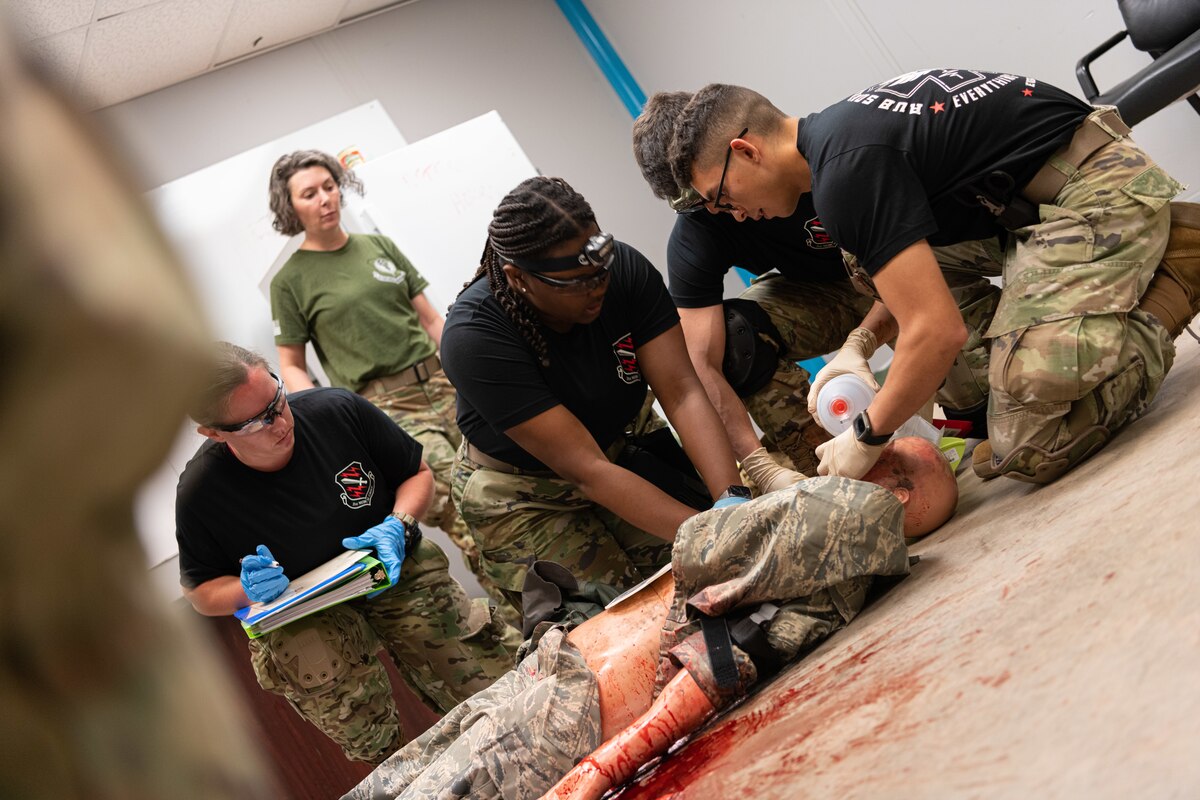 U.S. Air Force Airmen assigned to the 21st Medical Group, Peterson Space Force Base, Colorado, provide tactical combat casualty care to a simulated trauma victim during exercise Medic Rodeo at Cannon Air Force Base, New Mexico, Aug. 13, 2024. In accordance with the Medic-X strategic initiative, every Air Force medic, including those not directly involved in patient care, needs to be proficient in 52 skills that ensure the Air Force's medical force is ready for the next fight. (U.S. Air Force photo by Senior Airman Drew Cyburt)