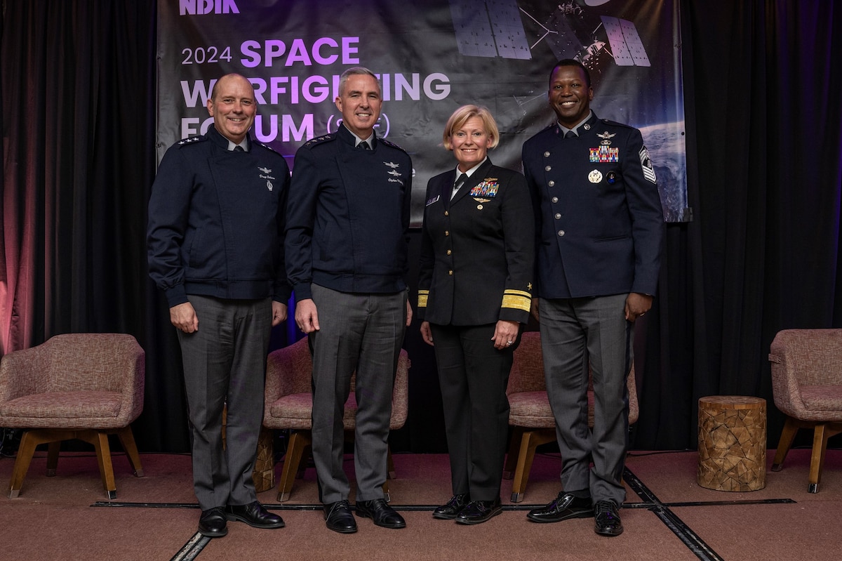 Four senior military officers pose while at a forum.