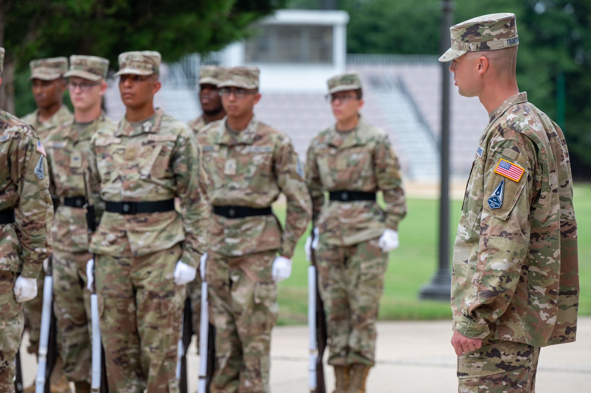 a technical training instructor with the United States Air Force Honor Guard, looks on as Honor Guard trainees of Class 24D work on their drill movements
