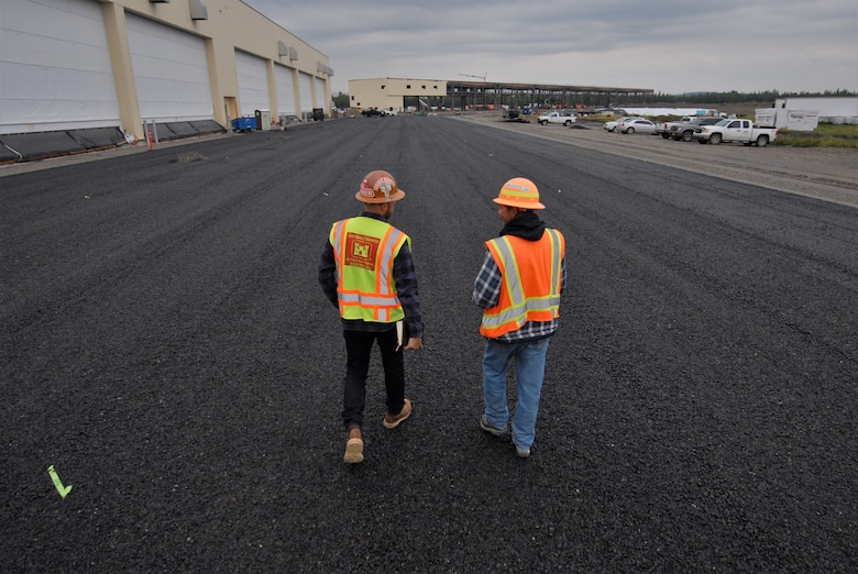 USACE construction personnel walk near a recently completed hangar complex for newly stationed F-35s at Eielson Air Force Base near North Pole, Alaska. The Department of Defense invested about $600 million on a beddown program at the installation located near North Pole, Alaska. Also known as the “joint strike fighter,” two new squadrons of 54 aircraft now have the proper facilities to support their missions thanks to the design and construction work of the U.S. Army Corps of Engineers – Alaska District.