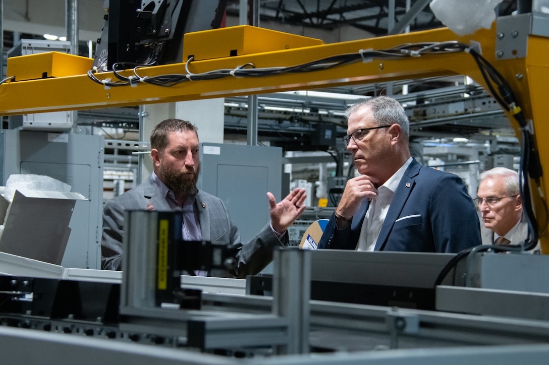 Two men talks amongst warehouse equipment