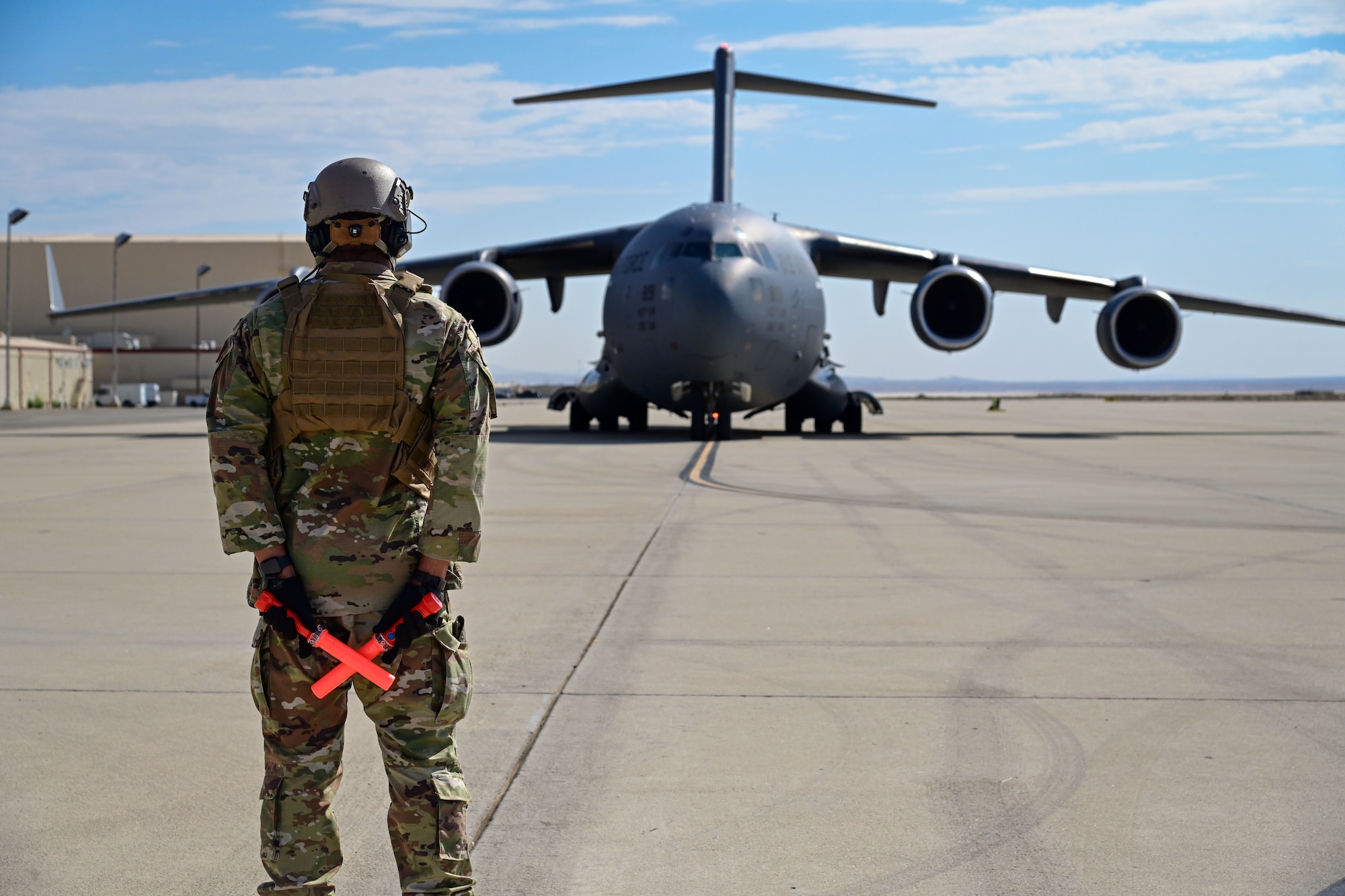 Service member stand in front of aircraft.