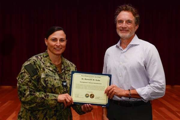 U.S. Navy Capt. Marcy Morlock, executive officer of Naval Medical Center San Diego, left, presents a joint outpatient experience survey 100% satisfaction award to Dr. Kenneth Soda, right, during an awards presentation at NMCSD, Aug. 7, 2024. The mission of NMCSD is to provide a superior experience for our staff, patients, and warfighters by delivering exceptional care afloat and ashore. NMCSD employs more than 5,000 active-duty military personnel, civilians, and contractors in southern California to be the preferred choice and leader in compassionate and innovative healthcare. Anchored in excellence, committed to health! (U.S. Navy photo by Mass Communication Specialist 2nd Class Celia Martin)