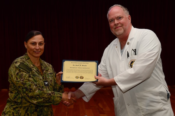 U.S. Navy Capt. Marcy Morlock, executive officer of Naval Medical Center San Diego, left, presents a joint outpatient experience survey 100% satisfaction award to Dr. Kent Blade, right, during an awards presentation at NMCSD, Aug. 7, 2024. The mission of NMCSD is to provide a superior experience for our staff, patients, and warfighters by delivering exceptional care afloat and ashore. NMCSD employs more than 5,000 active-duty military personnel, civilians, and contractors in southern California to be the preferred choice and leader in compassionate and innovative healthcare. Anchored in excellence, committed to health! (U.S. Navy photo by Mass Communication Specialist 2nd Class Celia Martin)