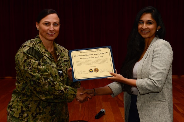 U.S. Navy Capt. Marcy Morlock, executive officer of Naval Medical Center San Diego, left, presents a joint outpatient experience survey 100% satisfaction award to Pharmacist Naureen Kazmi, right, during an awards presentation at NMCSD, Aug. 7, 2024. The mission of NMCSD is to provide a superior experience for our staff, patients, and warfighters by delivering exceptional care afloat and ashore. NMCSD employs more than 5,000 active-duty military personnel, civilians, and contractors in southern California to be the preferred choice and leader in compassionate and innovative healthcare. Anchored in excellence, committed to health! (U.S. Navy photo by Mass Communication Specialist 2nd Class Celia Martin)