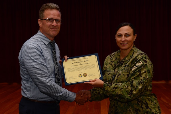 U.S. Navy Capt. Marcy Morlock, executive officer of Naval Medical Center San Diego, right, presents a joint outpatient experience survey 100% satisfaction award to Dr. Preston Gable, left, during an awards presentation at NMCSD, Aug. 7, 2024. The mission of NMCSD is to provide a superior experience for our staff, patients, and warfighters by delivering exceptional care afloat and ashore. NMCSD employs more than 5,000 active-duty military personnel, civilians, and contractors in southern California to be the preferred choice and leader in compassionate and innovative healthcare. Anchored in excellence, committed to health! (U.S. Navy photo by Mass Communication Specialist 2nd Class Celia Martin)