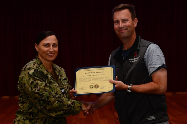 U.S. Navy Capt. Marcy Morlock, executive officer of Naval Medical Center San Diego, left, presents a joint outpatient experience survey 100% satisfaction award to Dr. William Bennett, right, during an awards presentation at NMCSD, Aug. 7, 2024. The mission of NMCSD is to provide a superior experience for our staff, patients, and warfighters by delivering exceptional care afloat and ashore. NMCSD employs more than 5,000 active-duty military personnel, civilians, and contractors in southern California to be the preferred choice and leader in compassionate and innovative healthcare. Anchored in excellence, committed to health! (U.S. Navy photo by Mass Communication Specialist 2nd Class Celia Martin)