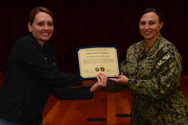 U.S. Navy Capt. Marcy Morlock, executive officer of Naval Medical Center San Diego, right, presents a joint outpatient experience survey 100% satisfaction award to Lt. Cmdr. Jaimie Gastwirt, left, during an awards presentation at NMCSD, Aug. 7, 2024. The mission of NMCSD is to provide a superior experience for our staff, patients, and warfighters by delivering exceptional care afloat and ashore. NMCSD employs more than 5,000 active-duty military personnel, civilians, and contractors in southern California to be the preferred choice and leader in compassionate and innovative healthcare. Anchored in excellence, committed to health! (U.S. Navy photo by Mass Communication Specialist 2nd Class Celia Martin)