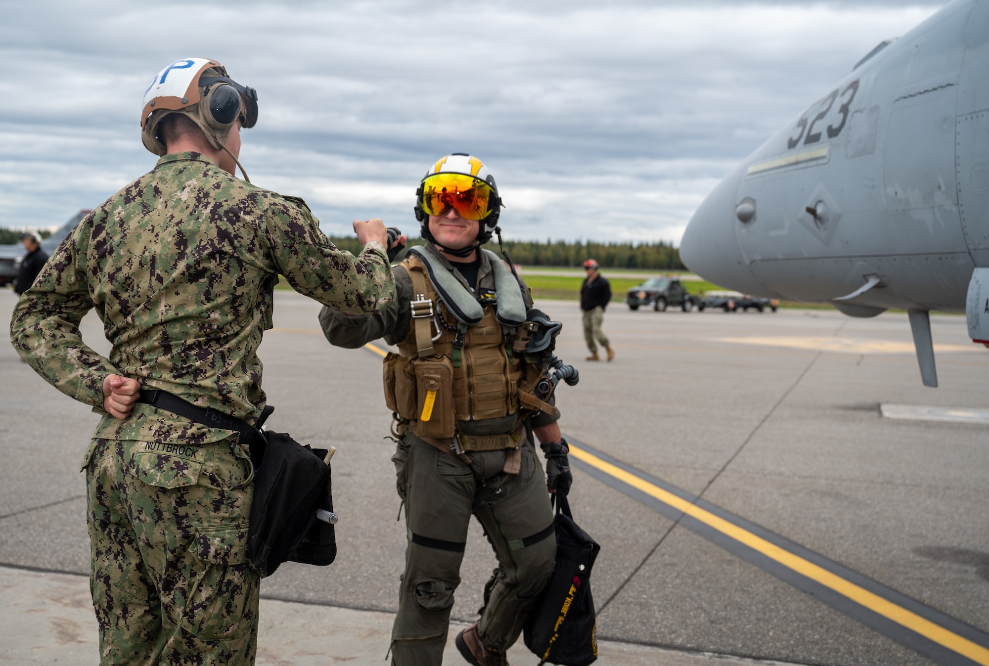 U.S. Navy Lt. Mark Gattmann, Electronic Attack Squadron 135 (VAQ-135) pilot, right, fist bumps U.S. Navy Aviation Machinist Mate Airman Ayden Nuttbrock, an Electronic Attack Squadron 135 (VAQ-135) plane captain, left, during Red Flag Alaska 24-3.