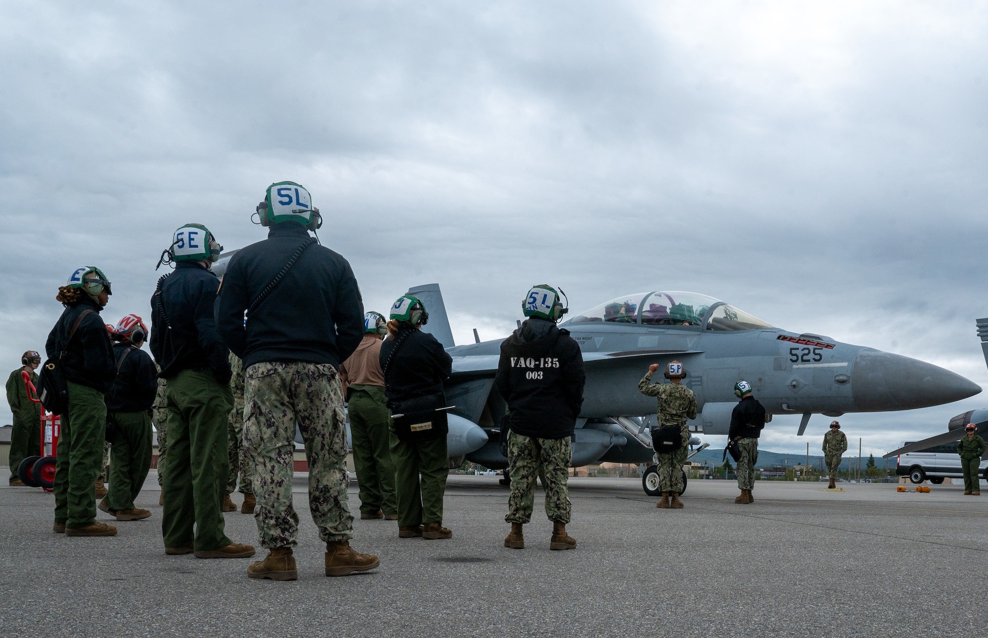 U.S. Navy Sailors, from the Electronic Attack Squadron 135 (VAQ-135) “Black Ravens,” stand prepared to perform any specialty maintenance needed for an EA-18G Growler, during Red Flag-Alaska 24-3, at Eielson Air Force Base, Alaska.