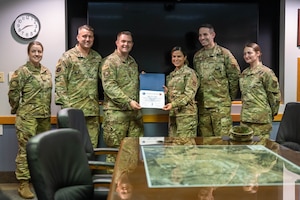 U.S. Air Force Master Sgt. Merari Antunez poses for a photo after receiving an award from the 439th Airlift Wing Diamond Council at Westover ARB, MA, 1 June 2024. She is holding the certificate and flanked by five members of the Council.  Antunez, 439 AW group administration superintendent, encountered and helped render aid to a woman choking at the Subway inside the Westover ARB Express gas station on Sunday, May 5, 2024.