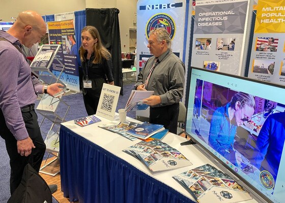 KISSIMMEE, FL (August 15, 2023) Naval Health Research Center’s Dr. Amy Silder (middle) and Dr. Ken Earhart (right) network at the 2023 Military Health System Research Symposium booth exhibit hall. This year, Dr. Silder will be presenting two posters: one on “Evaluating Physical Loads During Loaded Military Training Hikes Using a Minimal Sensor Set” and the other on “Association of Mild Traumatic Brain Injury and Risk of Musculoskeletal Injury Among United States Service Members.” NHRC supports military mission readiness with research and development that delivers high-value, high-impact solutions to the health and readiness challenges our military population faces on the battlefield, at sea, on foreign shores and at home. (U.S. Navy photo by John Marciano/Released)