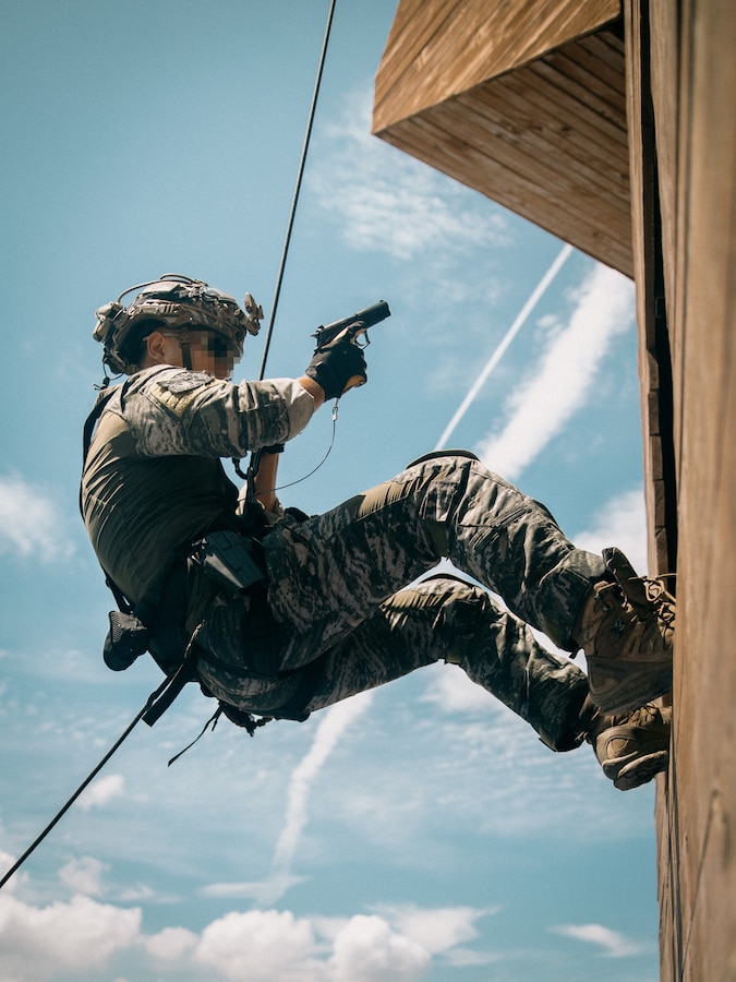 A Republic of Korea special reconnaissance marine assigned to 1st Reconnaissance Battalion, 1st ROK Marine Division, demonstrates clearing a window while rappelling for U.S. Marines assigned to Reconnaissance Company, 15th Marine Expeditionary Unit, during mountain rescue training at ROK Marine Corps Base Pohang, South Korea, Aug. 16, 2024. Integrated training between the two countries strengthens the ROK-U.S. Alliance through bilateral, joint training, contributing toward combined capability in defense of the Korean Peninsula. (U.S. Marine Corps photo by Cpl. Joseph Helms) (This photo has been altered for security purposes by blurring faces)