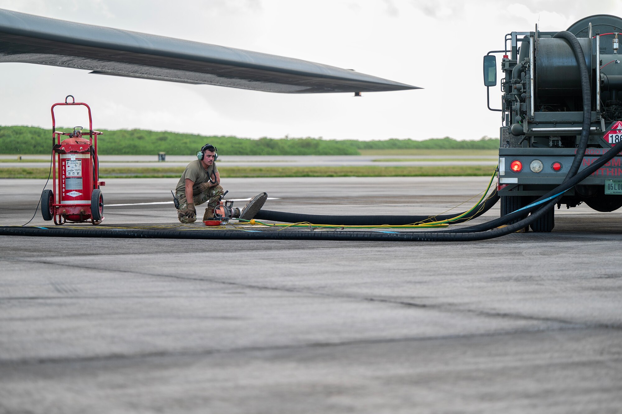 A U.S. Air Force Airmen assigned to the 110th Expeditionary Bomb Squadron conducts hot pit refueling on a B-2 Spirit stealth bomber during a Bomber Task Force mission at Diego Garcia, British Indian Ocean Territory, Aug. 21, 2024. Conducting hot pit events in various locations around the globe enables aircrew and support Airmen to maintain a high state of readiness and proficiency. (U.S. Air National Guard photo by Staff Sgt. Whitney Erhart)