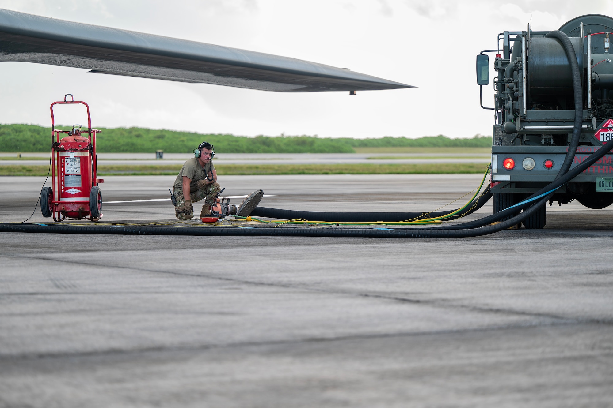 A U.S. Air Force Airmen assigned to the 110th Expeditionary Bomb Squadron conducts hot pit refueling on a B-2 Spirit stealth bomber during a Bomber Task Force mission at Diego Garcia, British Indian Ocean Territory, Aug. 21, 2024. Conducting hot pit events in various locations around the globe enables aircrew and support Airmen to maintain a high state of readiness and proficiency. (U.S. Air National Guard photo by Staff Sgt. Whitney Erhart)