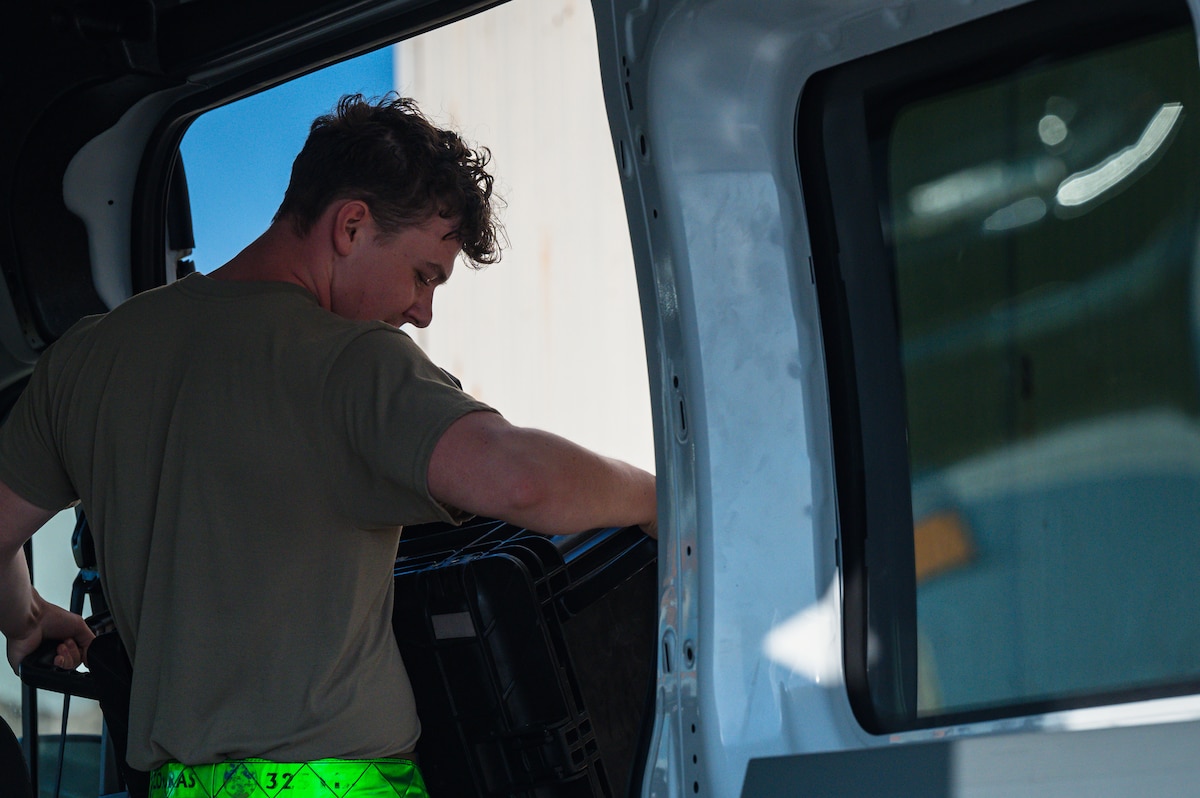 Airmen unloads box from vehicle