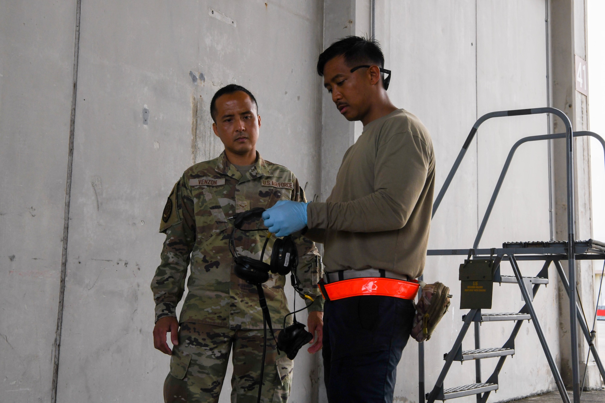 Two Airmen examine a headset.