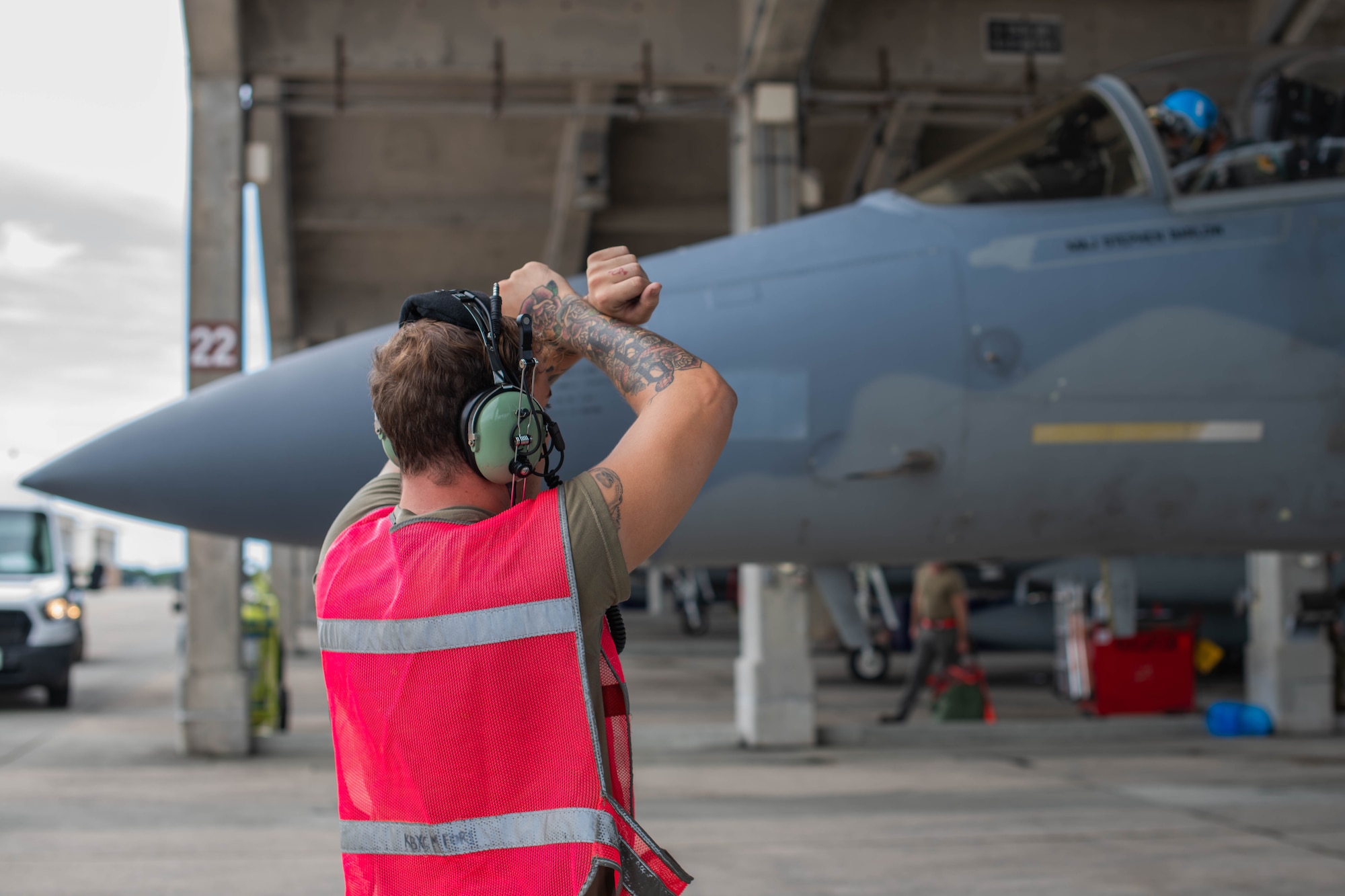 U.S. Air Force Airman Tyler Krueger, 18th Aircraft Maintenance Squadron assistant dedicated crew chief, marshals an F-15C Eagle before its final flight and retirement at Kadena Air Base, Japan, Aug. 15, 2024.