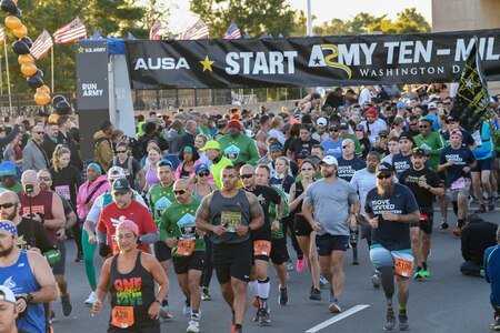 Hundreds of runners run past the starting line of the Army Ten-Miler Race.