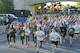 Hundreds of runners are running down a street during the Army Ten-Miler race.